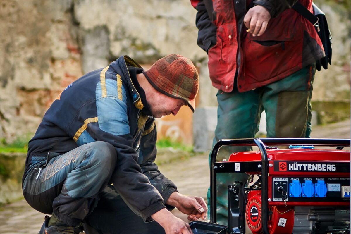 Technici nastartují záložní elektrocentrálu venku u budovy